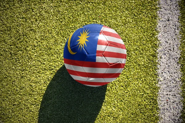 Fotbalový míč s státní vlajka Malajsie leží na hřišti — Stock fotografie