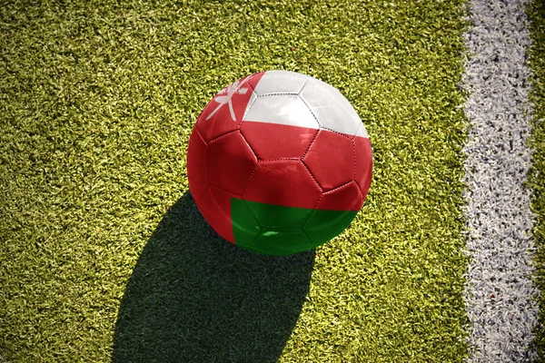 オマーンの国旗とサッカー ボールがフィールドにあります。 — ストック写真