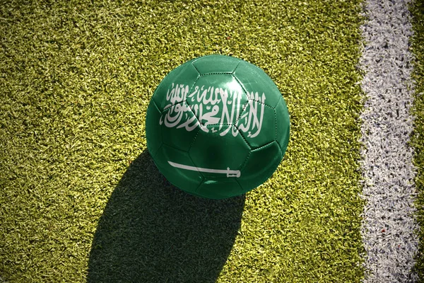 Pelota de fútbol con la bandera nacional de Arabia Saudí yace en el campo —  Fotos de Stock