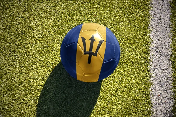 バルバドスの国旗とサッカー ボールがフィールドにあります。 — ストック写真