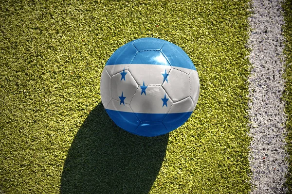 ホンジュラスの国旗とサッカー ボールがフィールドにあります。 — ストック写真