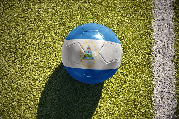 Football ball with the national flag of nicaragua lies on the field — Stock Photo, Image