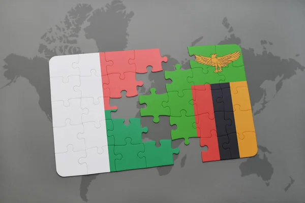 Puzzel met de nationale vlag van Madagaskar en zambia op een wereldkaart — Stockfoto