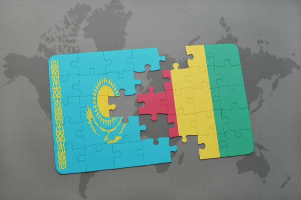 Quebra-cabeça com a bandeira nacional do Cazaquistão e da Guiné em um mapa mundial — Fotografia de Stock
