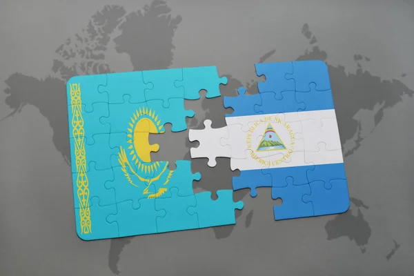 Rompecabezas con la bandera nacional de Kazajstán y Nicaragua en un mapa del mundo — Foto de Stock
