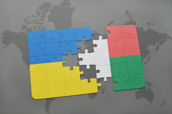 Rompecabezas con la bandera nacional de Ucrania y Madagascar en un mapa del mundo — Foto de Stock