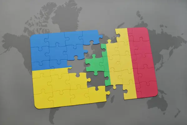 Puzzel met de nationale vlag van Oekraïne en mali op een wereldkaart — Stockfoto