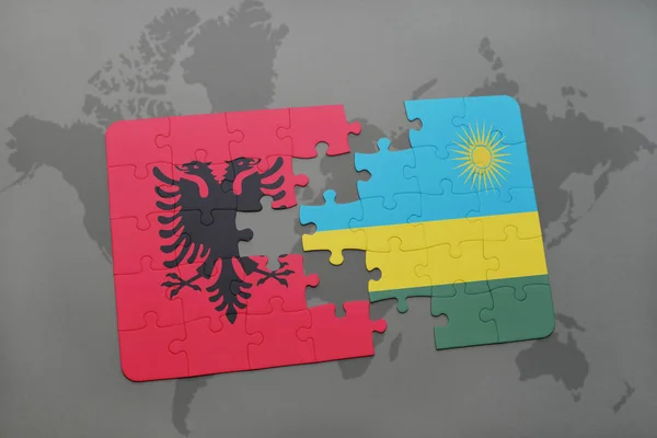 Puzzel met de nationale vlag van Albanië en rwanda op een wereldkaart — Stockfoto