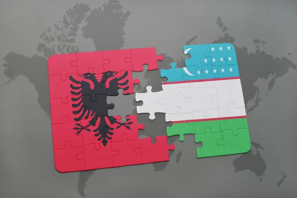 Puzzel met de nationale vlag van Albanië en Oezbekistan op een wereldkaart — Stockfoto