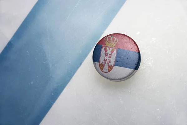 Oude hockeypuck met de nationale vlag van Servië. — Stockfoto