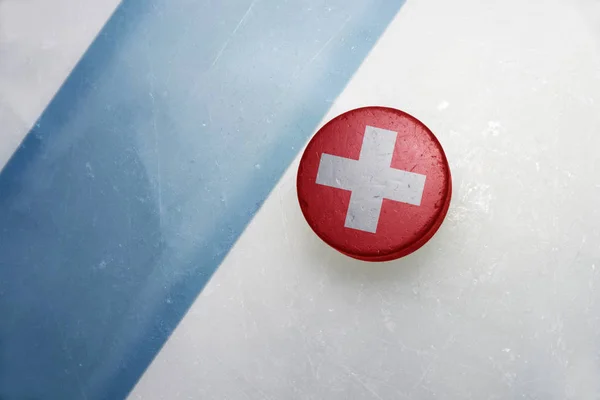 Oude hockeypuck met de nationale vlag van Zwitserland. — Stockfoto