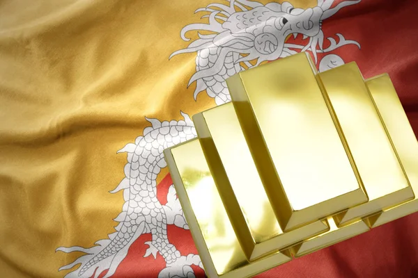 Brillanti lingotti d'oro sulla bandiera del Bhutan — Foto Stock