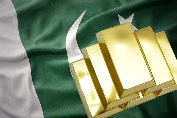 Lingots d'or brillant sur le drapeau du pakistan — Photo