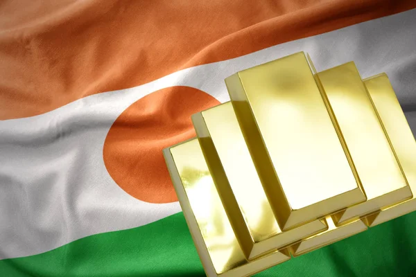 Brillantes lingotes dorados en la bandera de Níger —  Fotos de Stock