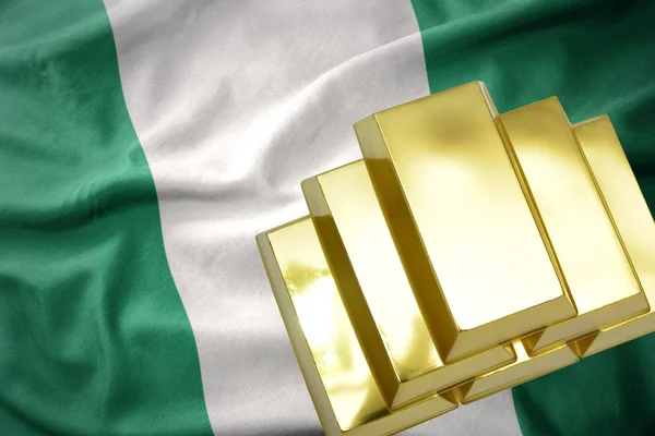 Brillantes lingotes dorados en la bandera de Nigeria — Foto de Stock
