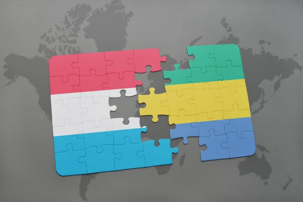 Puzzle con la bandiera nazionale di Lussemburgo e Gabon su una mappa del mondo — Foto Stock