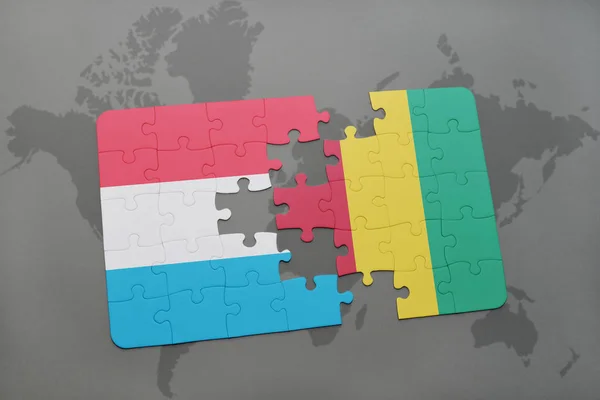 Puzzel met de nationale vlag van Luxemburg en Guinee op een wereldkaart — Stockfoto