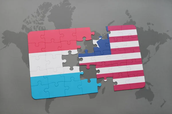 Puzzle con la bandiera nazionale di Lussemburgo e Liberia su una mappa del mondo — Foto Stock