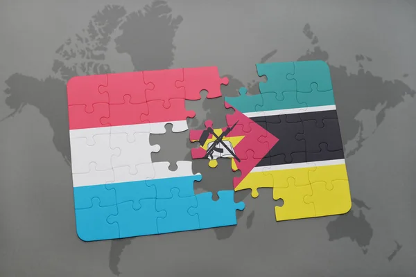 Puzzle con la bandiera nazionale di luxembourg e mozambique su una mappa del mondo — Foto Stock