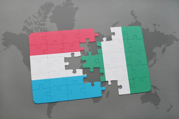 stock image puzzle with the national flag of luxembourg and nigeria on a world map