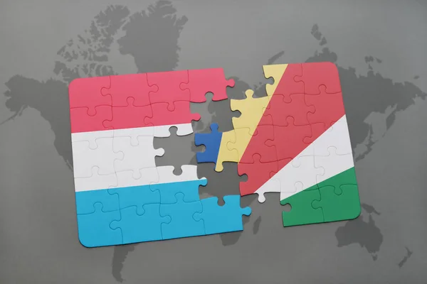 Puzzle con la bandiera nazionale di Lussemburgo e Seychelles su una mappa del mondo — Foto Stock