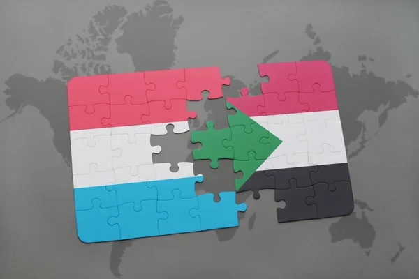 Puzzle con la bandiera nazionale di luxembourg e sudan su una mappa del mondo — Foto Stock