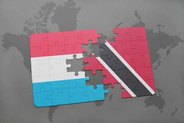 Puzzle con la bandiera nazionale di luxembourg e trinidad e tobago su una mappa del mondo — Foto Stock