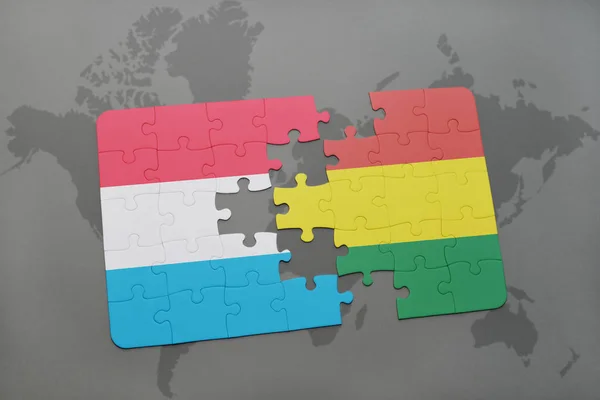 Puzzel met de nationale vlag van Luxemburg en bolivia op een wereldkaart — Stockfoto