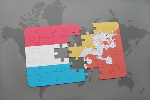Puzzel met de nationale vlag van Luxemburg en bhutan op een wereldkaart — Stockfoto