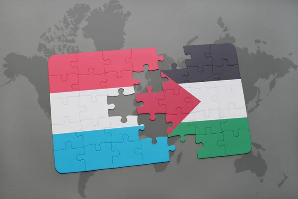 Quebra-cabeça com a bandeira nacional de Luxemburgo e Palestina em um mapa do mundo — Fotografia de Stock