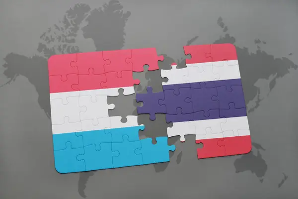 Puzzle con la bandiera nazionale di Lussemburgo e Thailandia su una mappa del mondo — Foto Stock