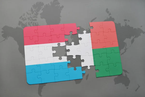 Rompecabezas con la bandera nacional de Luxemburgo y Madagascar en un mapa del mundo — Foto de Stock