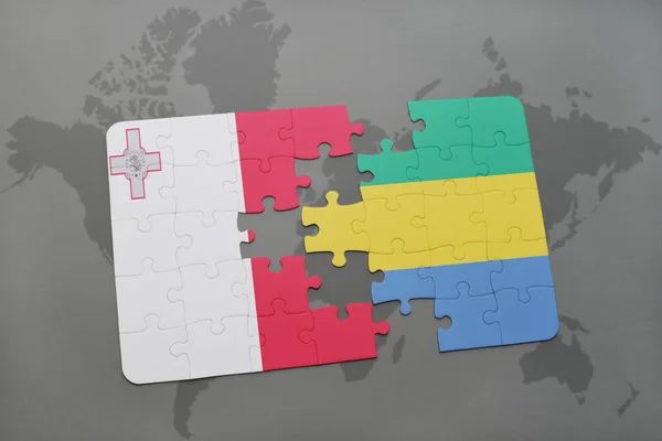 Puzzle with the national flag of malta and gabon on a world map — Stock Photo, Image