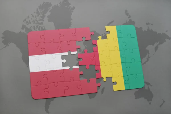 Puzzel met de nationale vlag van Letland en Guinee op een wereldkaart — Stockfoto