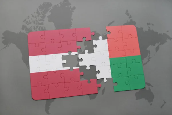 Puzzel met de nationale vlag van Letland en Madagaskar op een wereldkaart — Stockfoto