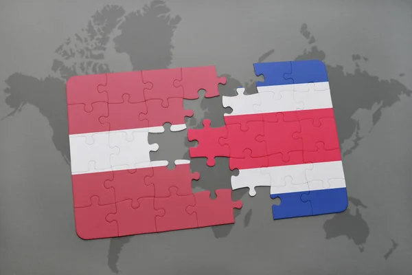Puzzel met de nationale vlag van Letland en costa rica op een wereldkaart — Stockfoto