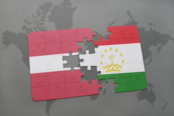 Quebra-cabeça com a bandeira nacional de latvia e tajiquistão em um mapa do mundo — Fotografia de Stock