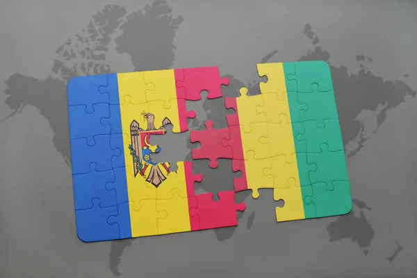 Puzzle with the national flag of moldova and guinea on a world map — Stock Photo, Image