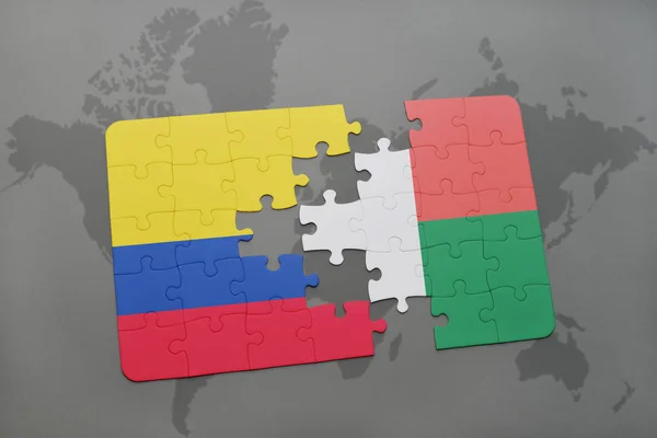Quebra-cabeça com a bandeira nacional da colômbia e madagáscar em um mapa do mundo — Fotografia de Stock