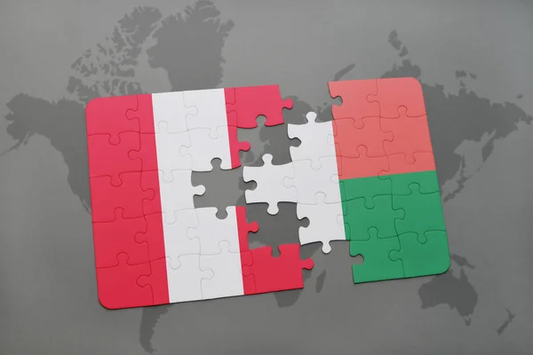 Peru ve Madagaskar ulusal bayrak bir dünya haritası üzerinde ile bulmaca — Stok fotoğraf