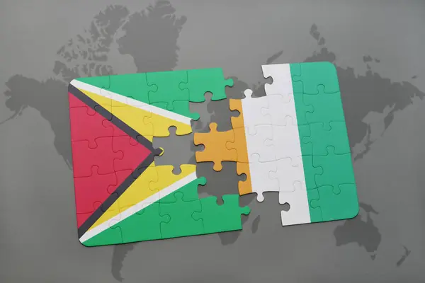 Rompecabezas con la bandera nacional de Guayana y Costa de Marfil en un mapa del mundo — Foto de Stock