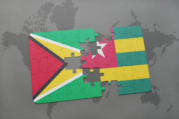 Quebra-cabeça com a bandeira nacional da Guiana e togo em um mapa do mundo — Fotografia de Stock
