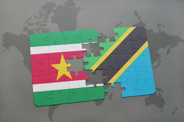 Rompecabezas con la bandera nacional de surinam y tanzania en un mapa del mundo — Foto de Stock