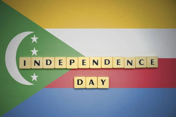 Letters with text independence day on the national flag of comoros. — Stock Photo, Image