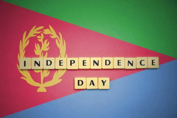 Briefe mit Text Unabhängigkeitstag auf der Nationalflagge von Eritrea. — Stockfoto