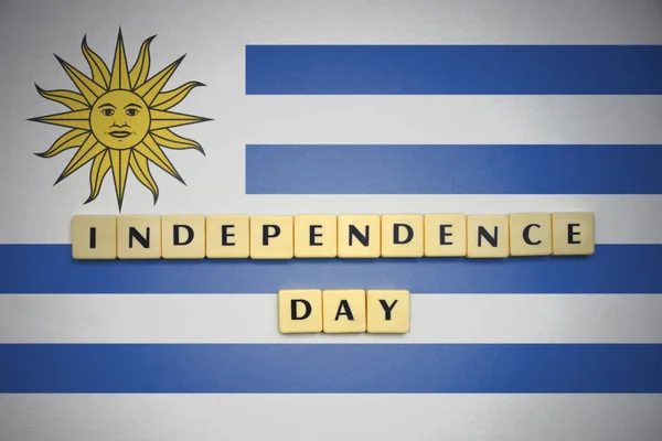 Brieven met de dag van de onafhankelijkheid van de tekst op de nationale vlag van uruguay. — Stockfoto