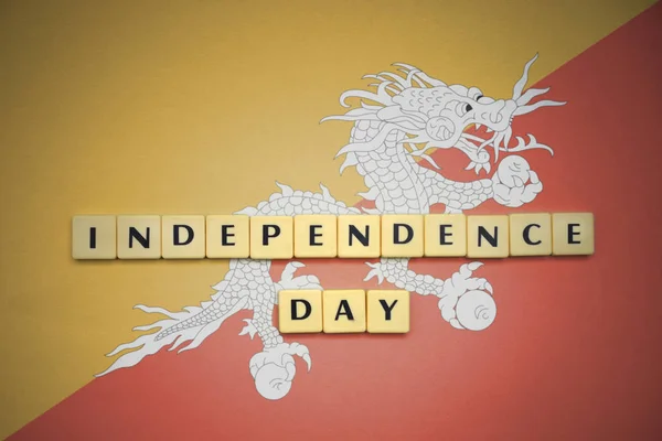 Cartas con el texto día de la independencia en la bandera nacional de Bután . — Foto de Stock