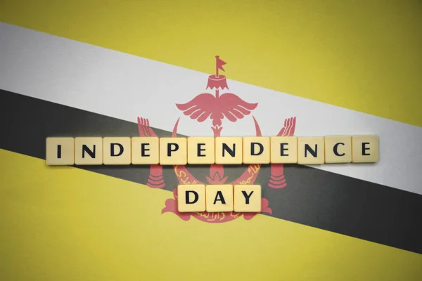 Letters with text independence day on the national flag of brunei. — Stock Photo, Image