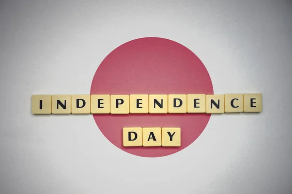 Cartas con el texto día de la independencia en la bandera nacional de Japón . — Foto de Stock