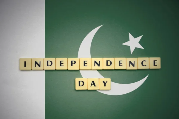 Cartas con el texto día de la independencia en la bandera nacional de Pakistán . — Foto de Stock